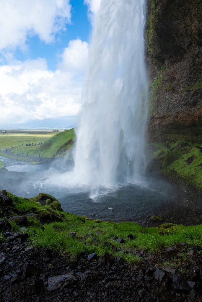 Behind Seljalandsfoss in Iceland on a sunny day